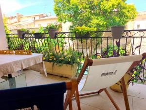 a balcony with a chair and a table and a fence at VILLA ADOYA Chambre d'hôtes Aigues-Mortes intra muros au calme climatisation réversible PISCINE WIFI ascenseur PARKING gratuit in Aigues-Mortes