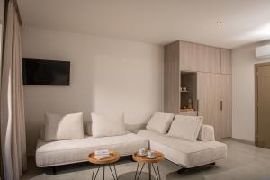 a living room with a couch and two tables at Parthenis Hotel & Suites in Malia