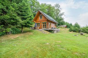 a wooden house on a grassy field with trees at Jäckleshof in Sankt Georgen im Schwarzwald