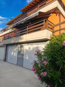 a building with two garage doors and a balcony at Casa Panorama Intelvi - Como & Lugano Lakes in Laino