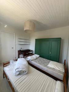two beds in a room with green cabinets at House with large garden Audenge in Audenge