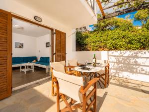 a dining room with a table and chairs on a patio at Villa Sofia in Agios Petros
