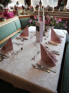 a table with a white table cloth with napkins and glasses at Hotel-Gasthof Lamm in Rot am See