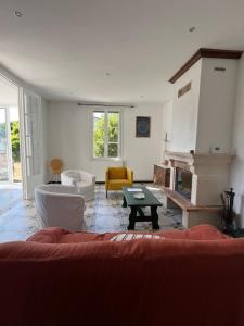 a living room with a couch and a fireplace at House with large garden Audenge in Audenge