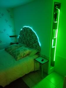 a bedroom with a bed with a green light at Les Jeux du Moulin in Nouans-les-Fontaines