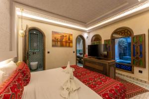 a large room with a bed and a television at Riad Secret Mahjouba in Marrakesh