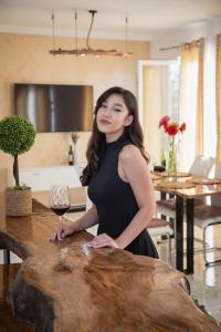 a woman standing at a table with a wine glass at Villa Enigma in Gevgelija
