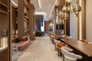 a restaurant with long tables and chairs and chandeliers at Doubletree By Hilton Tashkent in Tashkent