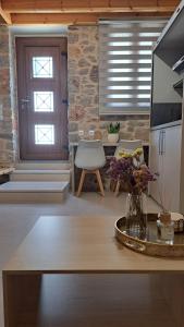a living room with a table with a vase of flowers at Stone house 2 in Líthion +11 photos