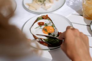 a person eating a plate of food on a table at Der Schlosswirt zu Anif - Biedermeierhotel und Restaurant in Anif