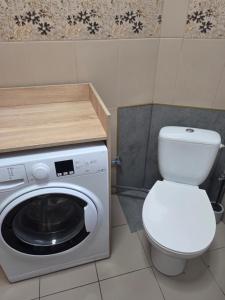 a bathroom with a toilet and a washing machine at Apartament Lipowa Centrum in Mrągowo