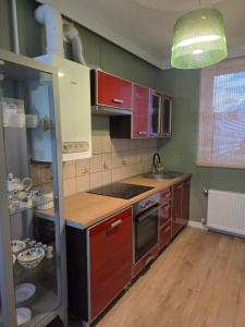 a kitchen with wooden cabinets and a stove top oven at Apartament Lipowa Centrum in Mrągowo +4 photos