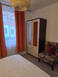 a bedroom with a bed and a chair and a window at Apartament Lipowa Centrum in Mrągowo