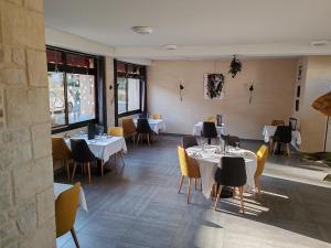 a restaurant with white tables and yellow chairs at Hotel O'Fun Art in Airvault
