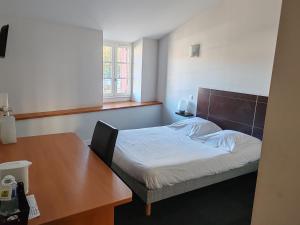 a small bedroom with a bed and a table at Hotel O'Fun Art in Airvault