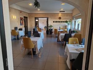 a restaurant with white tables and yellow chairs at Hotel O'Fun Art in Airvault +23 photos