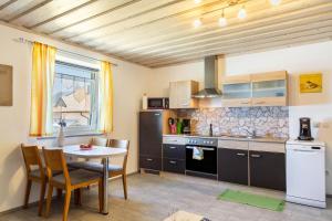 a kitchen with a table and a table and chairs at Die Moderne Fewo in Breitenberg