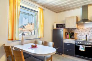 a small kitchen with a table and a window at Die Moderne Fewo in Breitenberg +9 photos