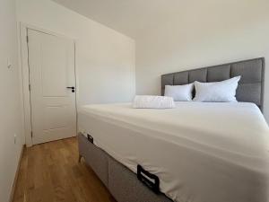 a bedroom with a large bed with white sheets at Olive Šušanj Apartment in Bar