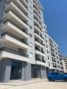 a blue car parked in front of a building at Olive Šušanj Apartment in Bar
