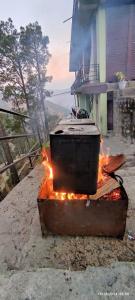 a pot on fire in front of a house at Bhandari Cottages in Dhanaulti