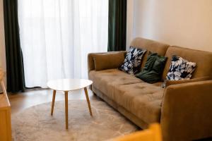 a living room with a couch and a table at Polanica Park, Sun&Snow in Polanica-Zdrój