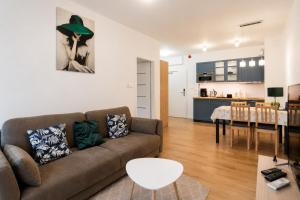 a living room with a couch and a dining room at Polanica Park, Sun&Snow in Polanica-Zdrój