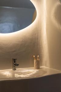a bathroom sink with two toothbrushes in a holder at Ornos Collection - by Hospirit in Ornos +49 photos