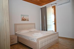 a bedroom with a white bed with towels on it at Golden Berden Boutique Apart-Hotel in Sarandë