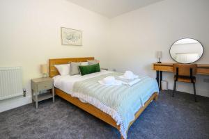 a bedroom with a bed with a mirror and a desk at Maesteg Road - Large House - Sleeps 10 - Gateway to Afan Forest and Bike Trails in Dyffryn