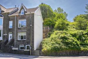 an old brick house with a stone wall at Maesteg Road - Large House - Sleeps 10 - Gateway to Afan Forest and Bike Trails in Dyffryn