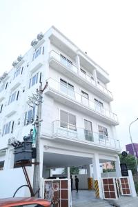 a white building with people standing in front of it at Kings Residency in Chennai