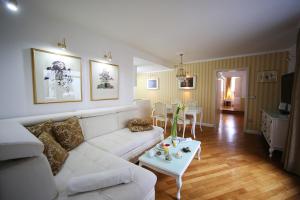 sala de estar con sofá blanco y mesa en ApartHotel Vila Minka, en Liubliana