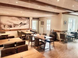 a restaurant with tables and chairs and a painting on the wall at Alpenstube Ockholm in Ockholm
