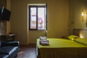 a bedroom with a green bed and a window at Casale Incanto in Terracina