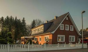 a house with a white fence in front of it at Ferienwohnung Schoon, 85042 in Ostrhauderfehn