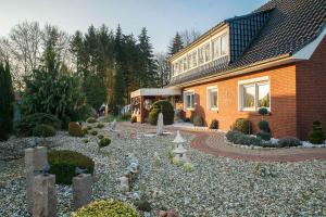 a house with a garden in front of it at Ferienwohnung Schoon, 85042 in Ostrhauderfehn