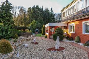 a garden in front of a house with a building at Ferienwohnung Schoon, 85042 in Ostrhauderfehn