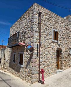 a stone building with a red fire hydrant in front of it at Stone house 1 in Líthion