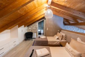 a bedroom with two beds in a room with wooden ceilings at Τilevoides Nisi Villas in Spartokhórion