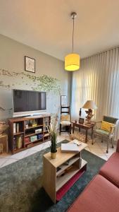 a living room with a couch and a flat screen tv at L Ecureuil Ludique in Beaumont-le-Roger