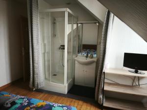 a bathroom with a glass shower and a sink at Villa les ecluses in Le Crotoy