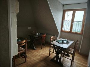 a dining room with two tables and chairs and a window at Villa les ecluses in Le Crotoy