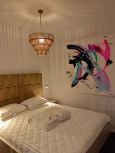 a bedroom with a bed and two chandeliers at Studios zur Schmiede in Weyregg