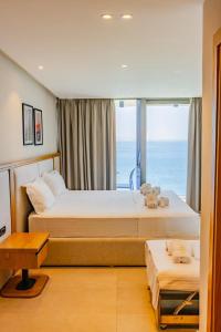 two beds in a room with a large window at Sunrise Qeparo in Qeparo