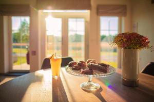 a table with a plate of donuts and an orange juice at Chalets Franciska Major, Pro Village in Sopronkövesd +19 photos