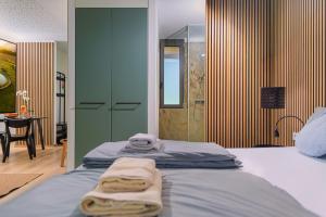 a bedroom with a bed with towels on it at Chalets Franciska Major, Pro Village in Sopronkövesd