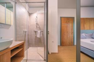 a bathroom with a shower and a sink and a bed at Chalets Franciska Major, Pro Village in Sopronkövesd