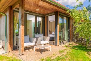 a screened in porch with a couch and a table at Chalets Franciska Major, Pro Village in Sopronkövesd
