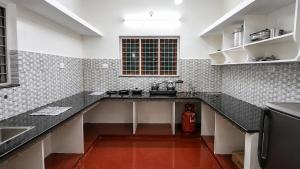 a kitchen with a large counter with a sink at Canorix Inn in Athirappilly